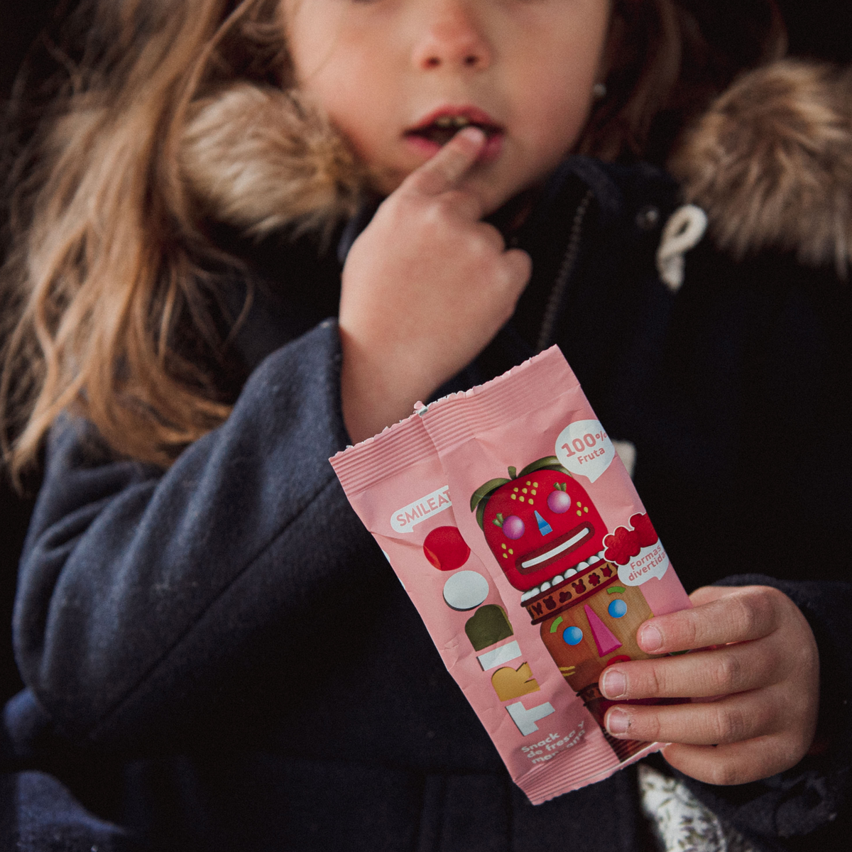 child eating a strawberry and apple snack